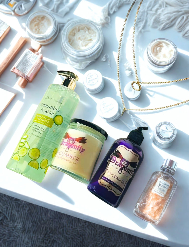 Collection of body care products including cucumber facial cleanser, candle , lotion, soap and necklace on a textured surface.