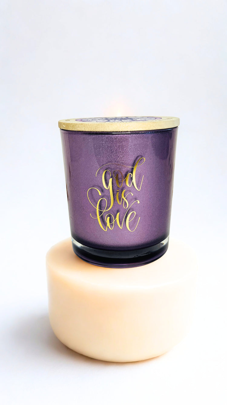 Purple candle with 'God is Love' text on a white background
