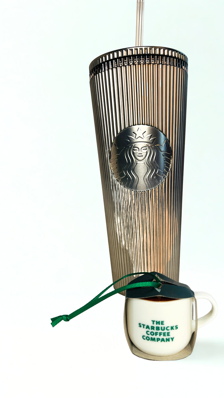 Gold Starbucks tumbler with ornament on a white background