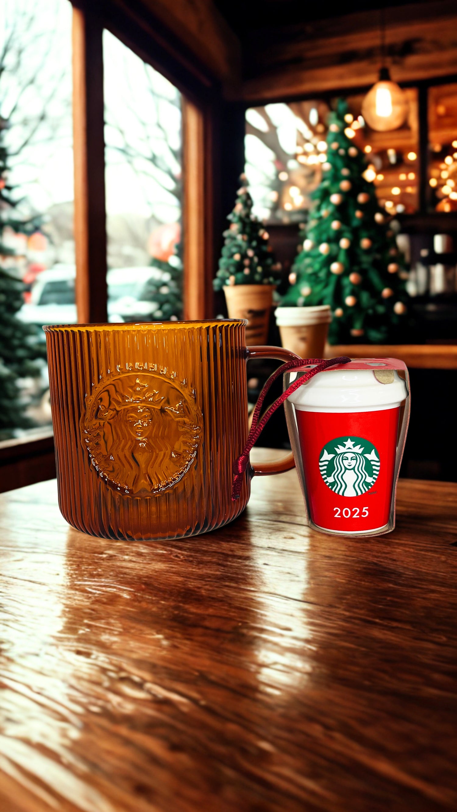 Starbucks mug and a ornament on a wooden table with Christmas decorations in the background