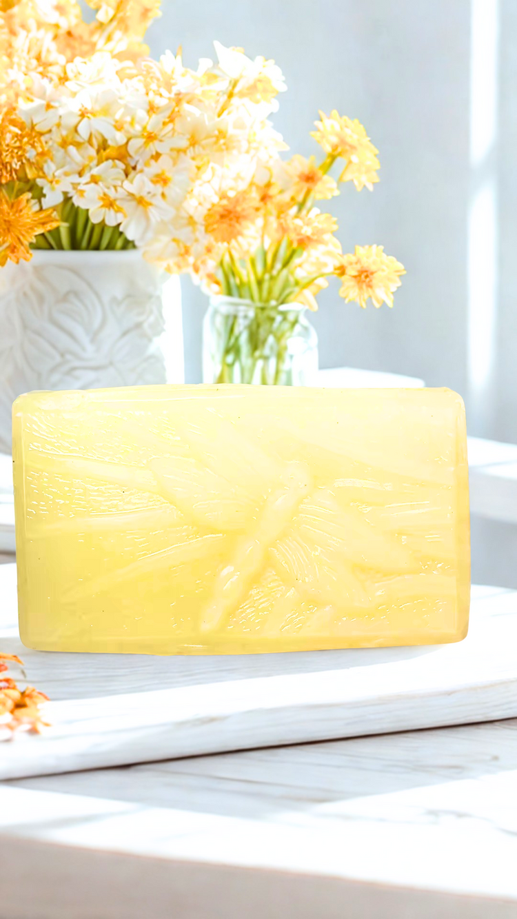 Fallen Leaves soap bar on a white surface with flowers in the background