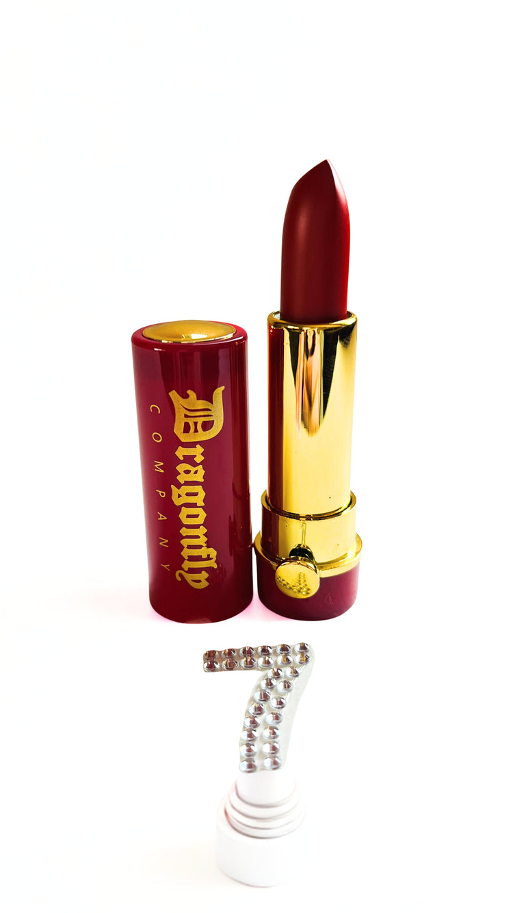 Burgundy lipstick with gold accents and 'Dragonfly' branding on a white background