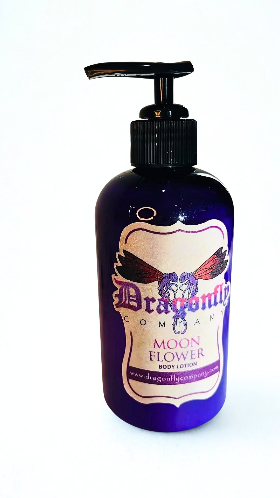 A bottle of Dragonfly Company Moon Flower Body Lotion, featuring a dark purple bottle with a black pump dispenser and a cream-colored label with purple and red text and graphics.