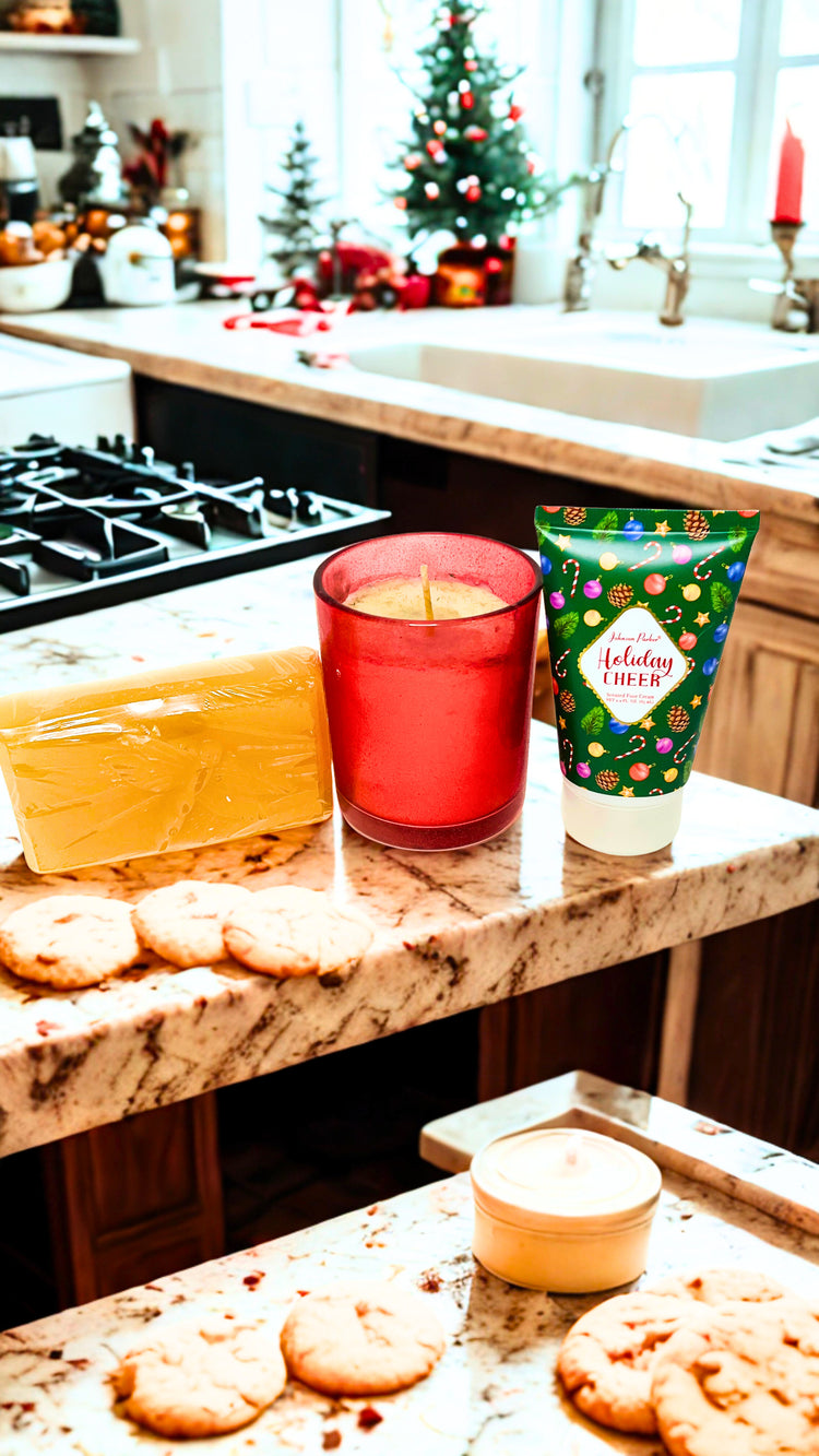 Candle, cookies, soap  and a tube of foot cream on a kitchen counter with a Christmas tree in the background.